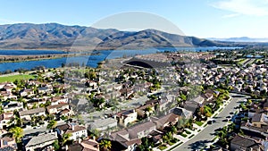 Aerial view of identical residential subdivision house with big lake and mountain on the background