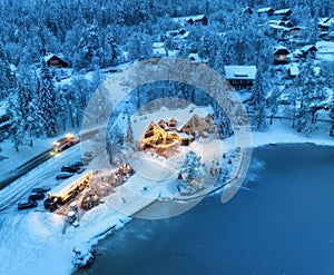 Aerial view of illuminated houses in snowy village at night