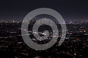 Aerial view of illuminated modern cityscape with sky in background at night