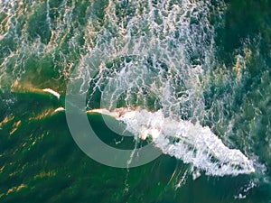Aerial view of indistinguisable man surfing in Barra da Tijuca beach