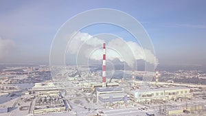 Aerial view industrial city and smoking chimney on winter landscape. Drone view smoke chimney pipe on chemical plant