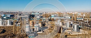 Aerial view of industrial factory or plant buildings with steel storage construction tanks and pipes