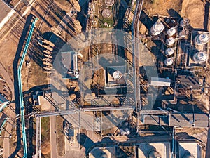 Aerial view of industrial factory or plant buildings with steel storage construction tanks and pipes, oil refinery concept
