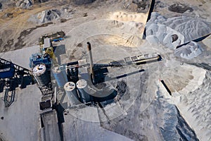 Aerial view of industrial mineral open pit mine. Opencast mining quarry with lots of machinery at work. Drone view from above