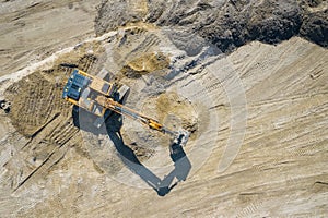 Aerial view of industrial mineral open pit mine. Opencast mining quarry with lots of machinery at work. Drone view from above