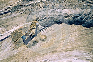 Aerial view of industrial mineral open pit mine. Opencast mining quarry with lots of machinery at work. Drone view from above