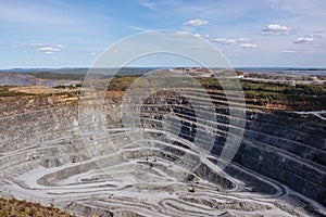 Aerial view industrial of opencast mining quarry with lots of machinery at wo