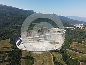 Aerial view industrial of opencast mining quarry with lots of machinery at work - crushed stone and building materials