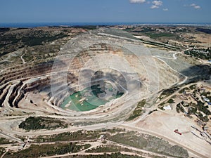 Aerial view industrial of opencast mining quarry with lots of machinery at work - extracting fluxes for the metal