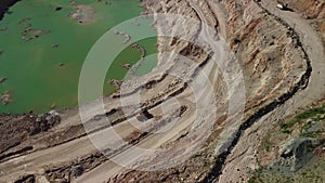 Aerial view of industrial opencast mining quarry with lots of machinery at work - extracting fluxes for the metal