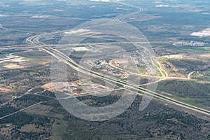 Aerial view of interstate highway and suburban subdivisions and warehouses under construction