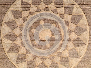 Aerial view of an intricate geometric crop circle formation in a wheat field in Wiltshire, England