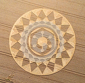 Aerial view of an intricate geometric crop circle formation in a wheat field in Wiltshire, England