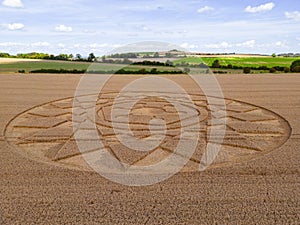 Aerial view of an intricate geometric crop circle formation in a wheat field in Wiltshire, England