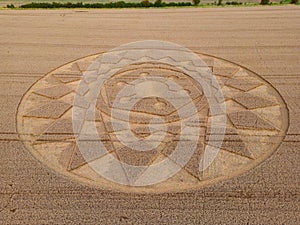 Aerial view of an intricate geometric crop circle formation in a wheat field in Wiltshire, England