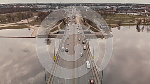 Aerial view of Island Bridge in Riga - Gloomy weather - Flight over river Daugava with clouds reflecting in the water