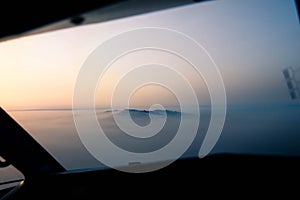 Aerial view of an island surrounded by mist at sunset