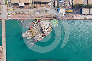 Aerial view of a jack up oil drilling rig and dry dock ship in the shipyard