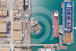 Aerial view of a jack up oil drilling rig and dry dock ship in the shipyard