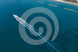 Aerial view of jet ski cruising at high speed on emerald sea water