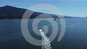 Aerial view of a jetski sailing in the blue water leaving a trail in Vancouver, Canada