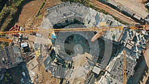 Aerial view jib of big tower crane lifts building materials on construction site