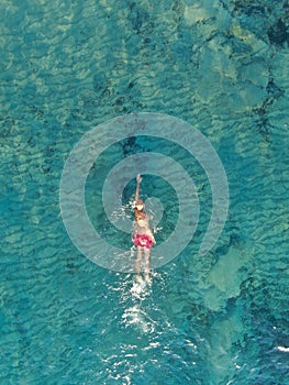 aerial view of joung man swiming on a beach of Majorca. Concept of holiday, summer, travel, tourism and relax