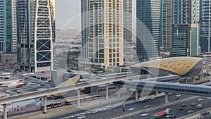 Aerial view of Jumeirah lakes towers skyscrapers day to night timelapse with traffic on sheikh zayed road.