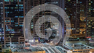 Aerial view of Jumeirah lakes towers skyscrapers night timelapse with traffic on sheikh zayed road.