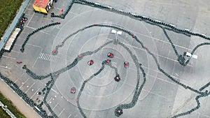 Aerial view of the karts pilots traning or competing on the karting trace in protective uniform and helmet. Media. Kart