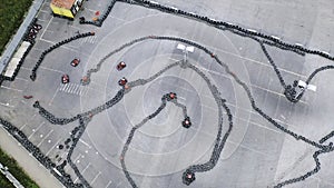 Aerial view of the karts pilots traning or competing on the karting trace in protective uniform and helmet. Media. Kart