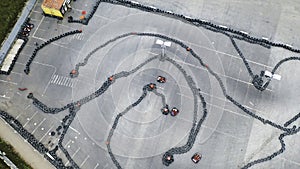 Aerial view of the karts pilots traning or competing on the karting trace in protective uniform and helmet. Media. Kart