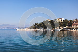 Aerial view of Kassiopi, village in northeast coast of Corfu island, Ionian Islands, Kerkyra, Greece in a summer sunny day, with