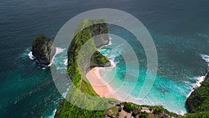 Aerial view of Kelingking sandy beach in tropical island Bali. Green cliff and deep blue ocean waves. Nusa Penida.