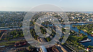 Aerial view of the Kherson city. A shipyard on the banks of the Dnieper River of which there are cranes and ships.