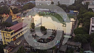 Aerial view of Kolkata city center at sunset. Indian city drone shot with warm light. Residential and religious building and birds