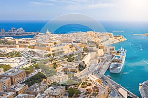 Aerial view of Lady of Mount Carmel church, St.Paul`s Cathedral and a great bay with a cruise liner ship in Valletta city, Malta