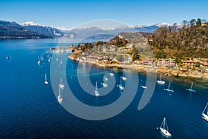 Aerial view of Lake Maggiore with boats in the harbor of Monvalle village, Italy