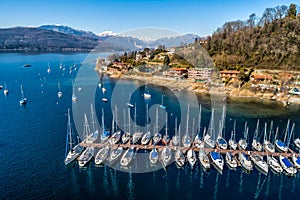 Aerial view of Lake Maggiore with boats in the harbor of Monvalle village, Italy