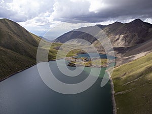 Aerial view of lake surrounded by snow mountain peaks in the Tian Shan Mountains of Kyrgyzstan