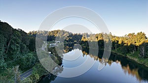 Aerial view of a lake surrounded by trees and their reflection in water