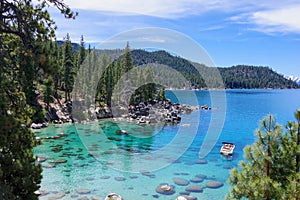 Aerial view of Lake Tahoe from the Nevada side with rocks and boat in the water.