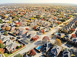 Aerial view lakeside subdivision with large house and colorful autumn leaves near Dallas