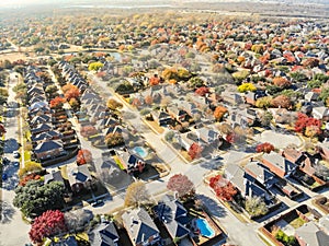 Aerial view lakeside subdivision with large house and colorful autumn leaves near Dallas