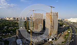 Aerial view of landscape in the city with under construction buildings and industrial cranes.