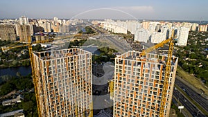 Aerial view of landscape in the city with under construction buildings and industrial cranes.