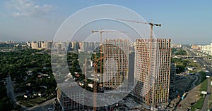 Aerial view of landscape in the city with under construction buildings and industrial cranes.