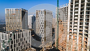 Aerial view of landscape in the city with under construction buildings and industrial cranes. Construction site.