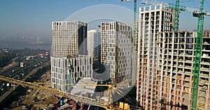 Aerial view of landscape in the city with under construction buildings and industrial cranes. Construction site.