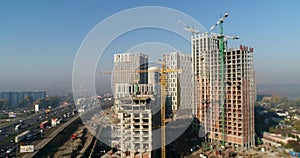 Aerial view of landscape in the city with under construction buildings and industrial cranes. Construction site.